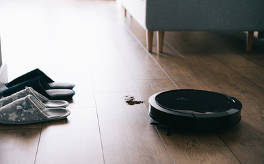 Robotic vacuum cleaner on laminate wooden floor, autonomous cleaning wireless technology. Smart...