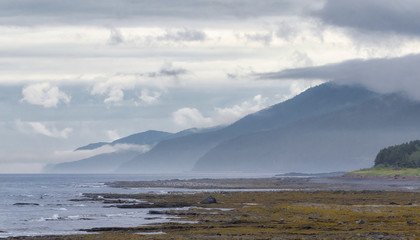 Coastline landscape under clouds near mountains