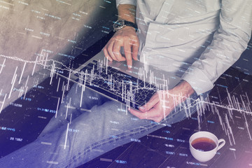 Forex graph with businessman working on computer in office on background. Concept of analysis. Double exposure.