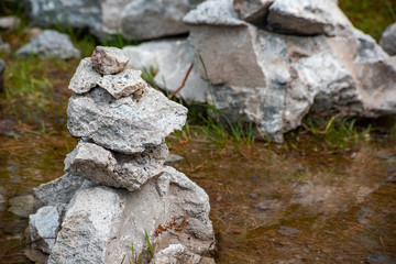 Stones are balancing on each other against the background of water is close