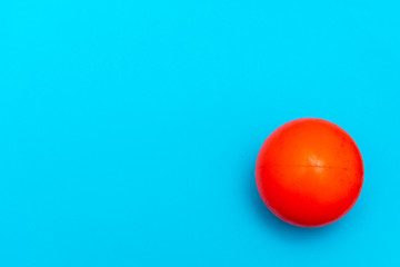 Red Ball hockey ball on a solid bright blue flat lay background symbolizing sports and activity with copy space.