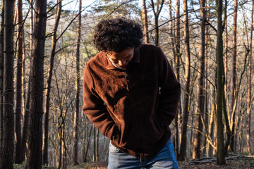 Man in a forest, walking, looking down