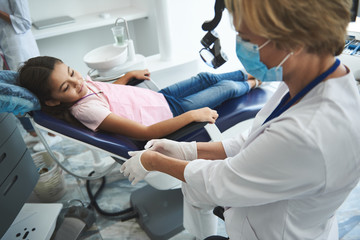 Obraz premium Relaxed girl is waiting for cavity check-up in office
