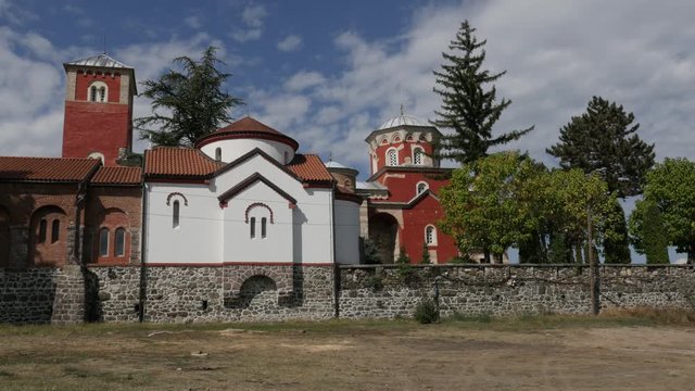 Defending walls and red facade of Zica orthodox monastery in Serbia 4K panning footage