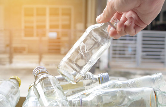 Hand Put An Empty Bottle Into The Recycle Bin