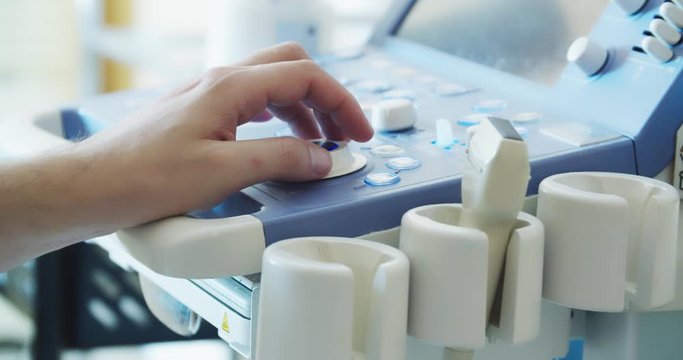 Doctor fixing setting on a USG Ultrasound device