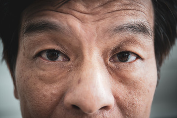 Detail of facial of Asian old man close up. processed in vintage color tone.
