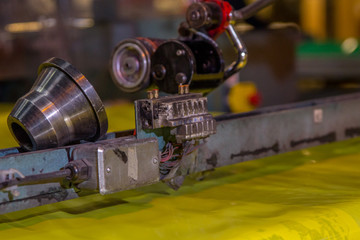 Close up shot of an industrial plastic slicing or cutting machine in heavy duty industrial factory producing mass packaging for outdoor and industry use. Not eco friendly contributing to pollution