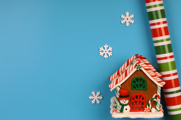 Christmas blue background. Toy house. Christmas snowflakes made of wood. Colored paper for wrapping gifts.