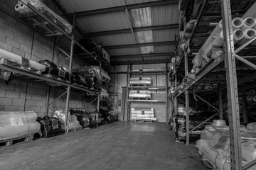 London,England, 28/1/19 Black and white image of the inside huge warehouse factory with shelfs stacked high with tubes and material up to the ceiling of the metal industrial building and large space