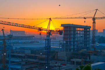 A construction site scene with cranes at night
