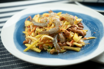 Spicy and sour mangoes salad with raw fresh shrimp