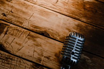 Retro microphone on warm wooden background with copy space for text