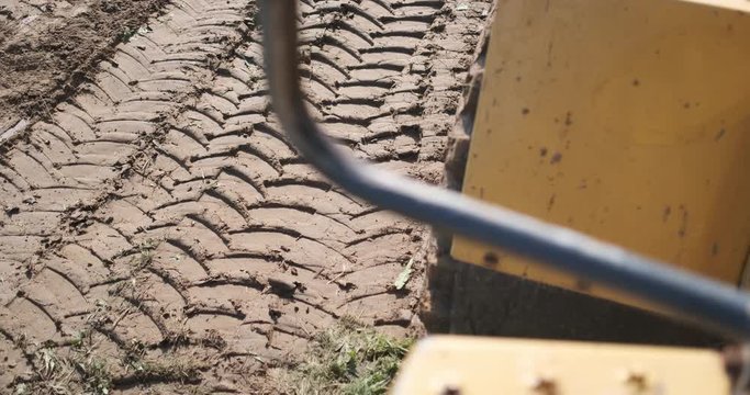 An excavator draws a tread on the ground. Slow motion.