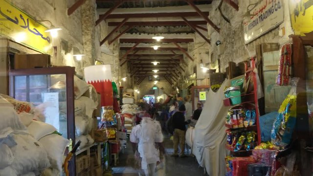 DOHA, QATAR- November 2019 Hyperlapse Crowd of people at Souq Waqif or the standing market. Qatar flag in shot