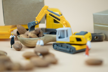 Miniature people worker move and select almonds for import and export.