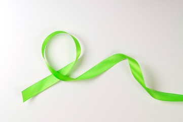 green ribbon on white background, holiday gift wrapping