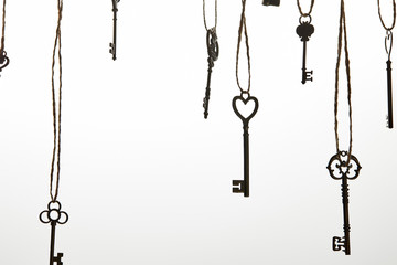 vintage keys hanging on ropes isolated on white