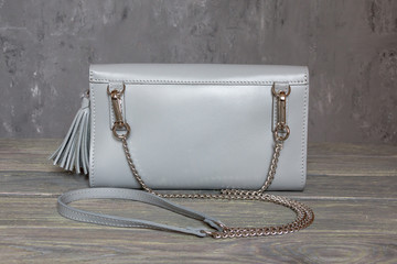 Beautiful small female handbag on grey background. Horizontal orientation. Minimalism fashion concept.