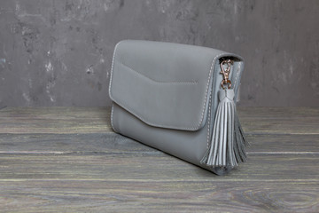 Beautiful small female handbag on grey background. Horizontal orientation. Minimalism fashion concept.