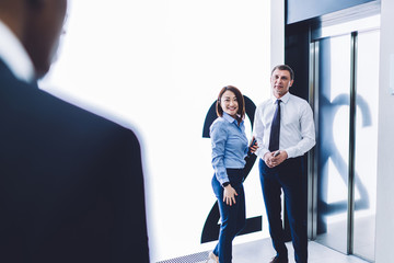 Multiracial coworkers having conversation in corridor in office