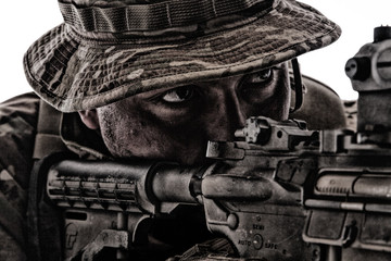 Close-up portrait of army soldier aiming rifle
