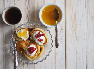 frozen berry red currant, honey, tea and pancakes on a wooden white tableOLYMPUS DIGITAL CAMERA
