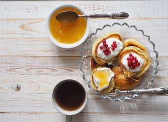 frozen berry red currant, honey, tea and pancakes on a wooden white tableOLYMPUS DIGITAL CAMERA