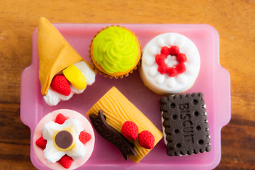 Plastic mini desert collection on a pink plastic plate