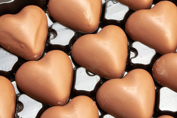 Multitude of heart-shaped milk chocolate in their box