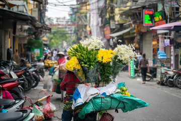 Flower vendor on Hanoi old town street at early morning