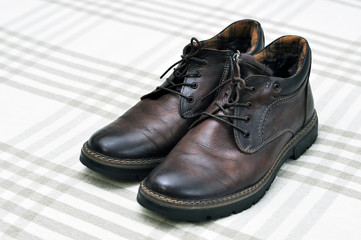 Men's insulated brown shoes made of genuine leather and with fur with lacing.
