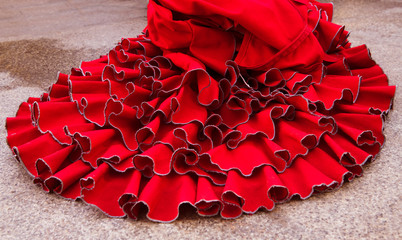 Colorful gipsy flamenco dress isolated on pavement. Flamenco dress of street artist closeup, part of the costume - obrazy, fototapety, plakaty