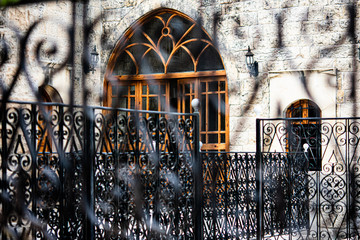 Entrance to a Lebanese stone house behind a blurred metal fence