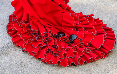 Colorful gipsy flamenco dress isolated on pavement. Flamenco dress of street artist closeup, part of the costume - obrazy, fototapety, plakaty