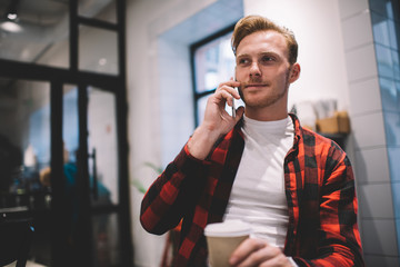 Calm man calling friend on mobile in cafe