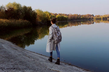 Full length portrait of young teenage girl walking near the lake. People, nature, travel concept.
