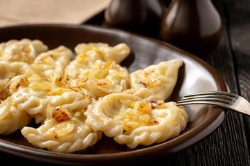 Mashed potato stuffed dumplings, served with fried onion and sour cream, Russian and Polish style cuisine. 
