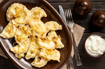 Mashed potato stuffed dumplings, served with fried onion and sour cream, Russian and Polish style cuisine. 