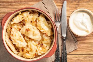Mashed potato stuffed dumplings, served with fried onion and sour cream, Russian and Polish style cuisine. 