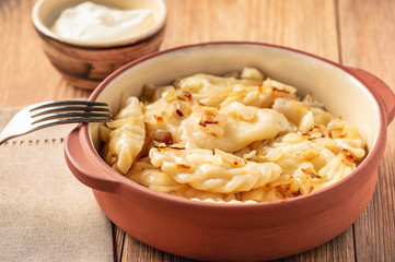 Mashed potato stuffed dumplings, served with fried onion and sour cream, Russian and Polish style cuisine. 