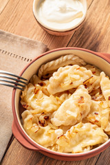 Mashed potato stuffed dumplings, served with fried onion and sour cream, Russian and Polish style cuisine. 