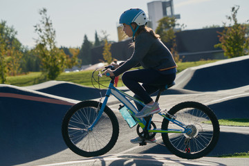 The bike lane for children. Children have fun on the race pump track. A child in a blue helmet...