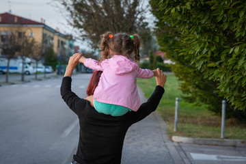 grandmother is carrying her granddaughter on her shoulders