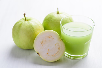 Green guava fruit and guava juice in glass on white background, high vitamin C healthy drink