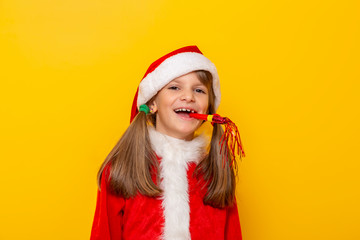 Little girl in Santa costume blowing party whistle