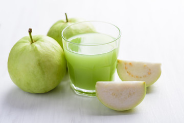Green guava fruit and guava juice in glass on white background, high vitamin C healthy drink