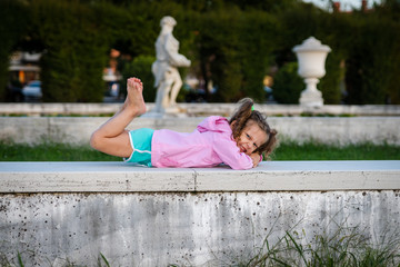 little girl is doing some gymnastics  out in the park