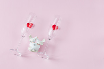 Fototapeta premium on a pink background, two glasses with hearts and a figure of two white doves in love