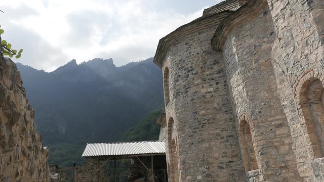 Olympus mountain and Agios Dionysios monastery buildings slow tilt 4K video